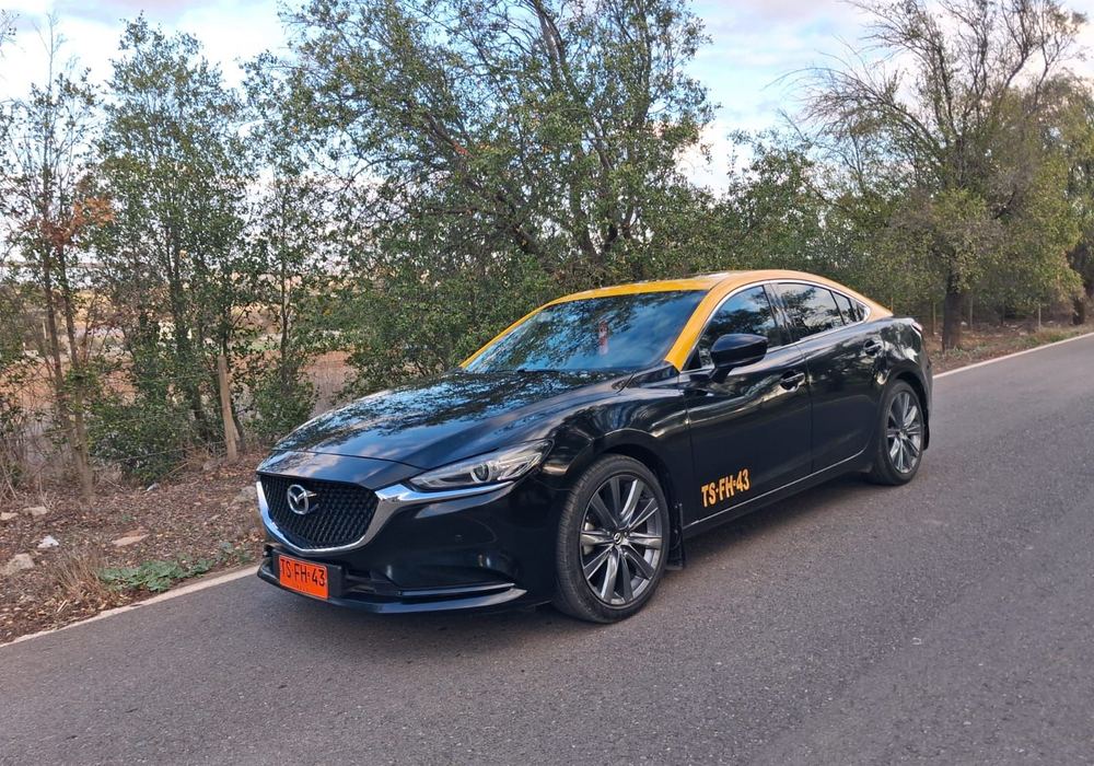 Auto ejecutivo negro con techo amarillo del servicio de taxi de Danyviajes